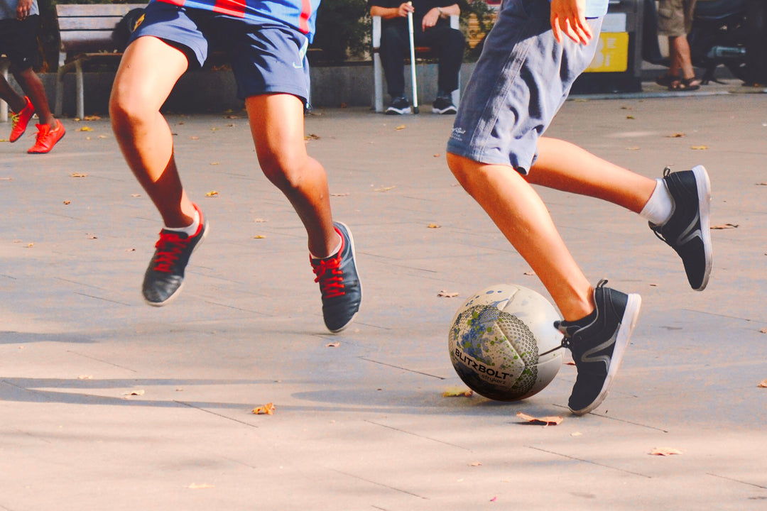 Kids playing and kicking a BlitzBolt soccer ball.