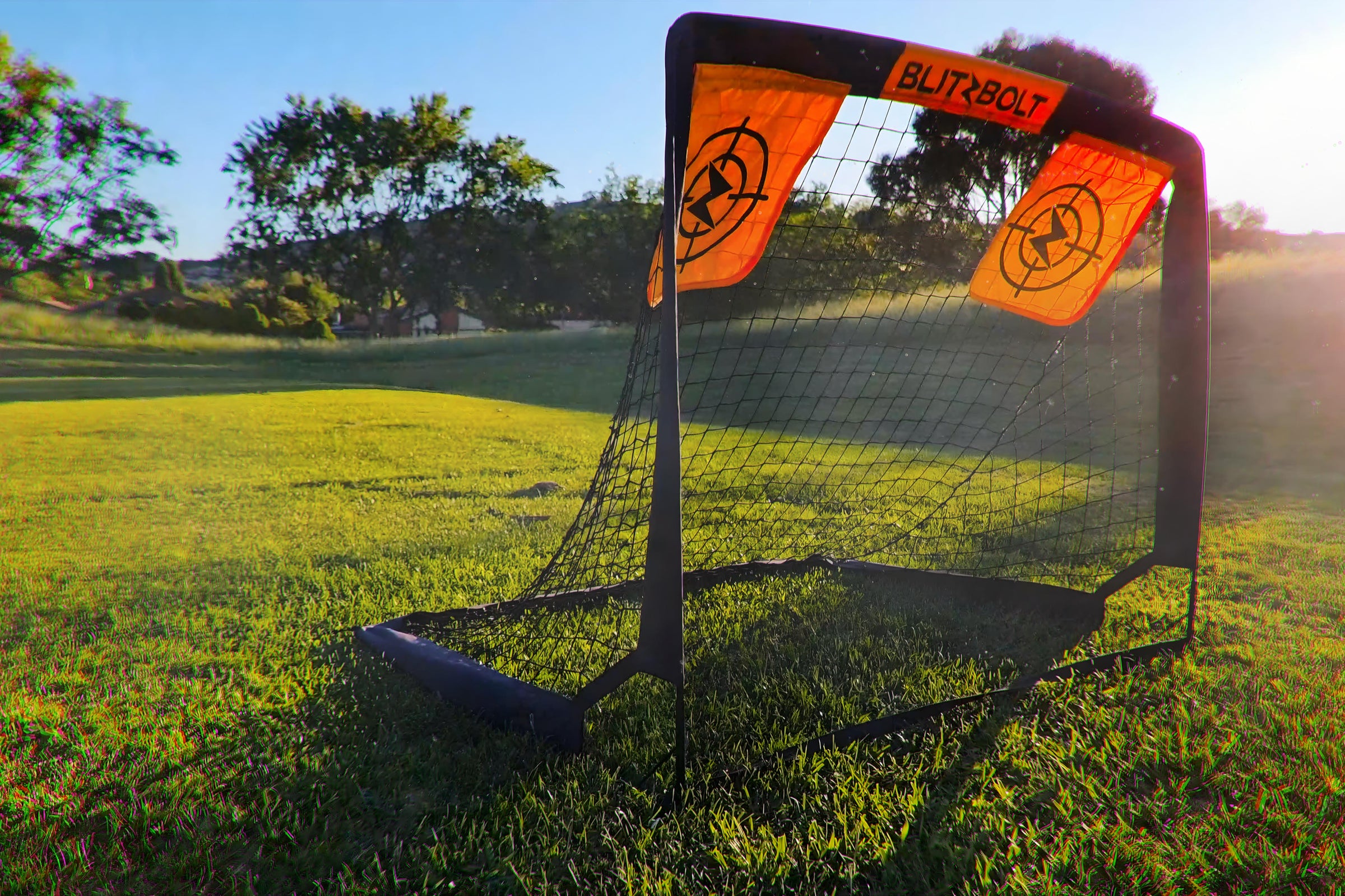 A BlitzBolt soccer goal in an outdoor setting, possibly a park or a backyard.